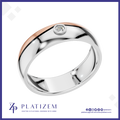A polished two-tone wedding band ring by Platzem, featuring a silver body with a rose gold inlay and a single round-cut clear gemstone in a bezel setting. The ring is displayed on a white background with a blue border and the Platzem brand logo at the bottom.