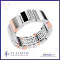 A 3D render of a Platizem geometric band ring, featuring white and rose gold geometric segments, black inlays, and clear gemstone accents, set against a white background with a blue border and brand logo.