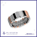 A men's segmented ring by Platzem, featuring a modern design with alternating rectangular silver and rose gold sections, a central channel of small clear stones, and a geometric openwork pattern on the lower band, set against a white background with a blue border.