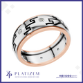 A platinum and rose gold ring with black Greek key patterns and small clear stones, shown on a white background with the brand logo 'PLATIZEM' at the bottom.