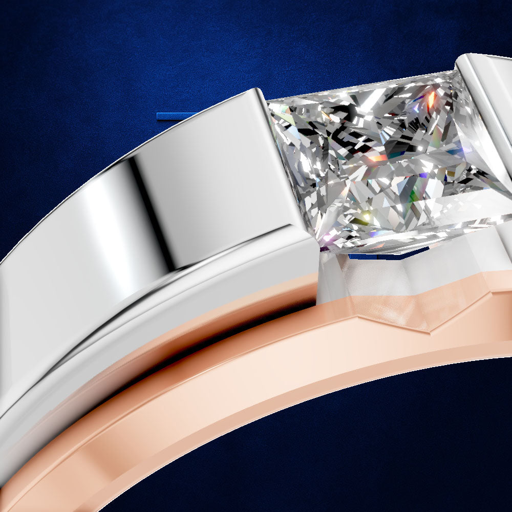 Close-up of a ring with a rectangular clear gemstone in a two-tone setting, featuring a silver band and a rose gold band, set against a dark blue textured background.