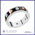 A platinum ring with a black enamel inlay, silver geometric accents, rose gold geometric accents, and small clear gemstones, shown on a white background with the brand logo 'PLATIZEM' at the bottom.