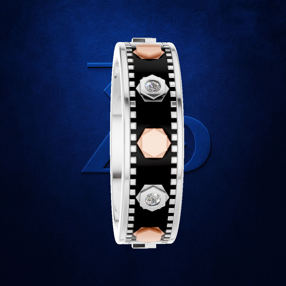 A silver-toned band ring with a black inlay, rose gold geometric accents, and small clear gemstones, shown on a dark blue textured background.