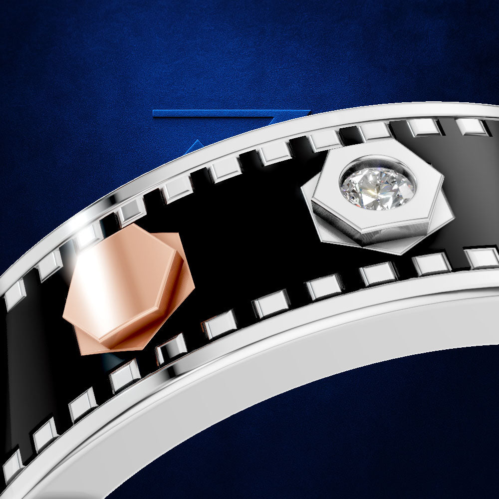 A close-up of a silver-toned ring featuring a black enamel inlay and a filmstrip design, with a rose gold geometric accent and a clear round gemstone in a silver bezel.