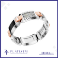 A luxury geometric ring by Platiszem, featuring a silver-toned textured band, a central rectangular inlay of clear pavé gemstones, and rose gold accents, set against a white background with a blue border.