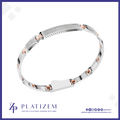 A silver-toned bangle bracelet with a central row of clear pavé stones and rose gold accent squares, displayed on a white background with the Platizem brand logo at the bottom.