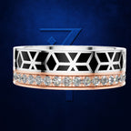 A wide geometric ring featuring a silver-toned top half with black inlay and white X-shaped lines, a rose gold bottom half with a row of clear gemstones, set against a dark blue textured background with a blue geometric logo.