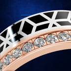 Close-up of a luxury ring featuring a rose gold band with a row of clear pavé diamonds and a white gold outer band with a black geometric inlay pattern, set against a dark blue background.