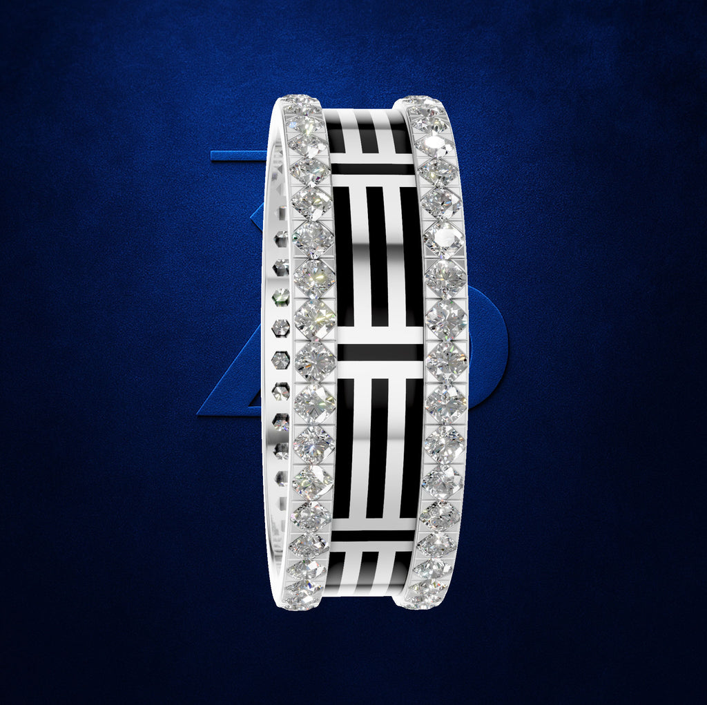 A wide silver band ring featuring a central black and white striped geometric pattern, flanked by rows of clear pavé-set stones on both sides, set against a dark blue textured background.