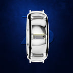 A top-down view of a white oval ring with a clear rectangular gemstone in the center, set against a textured dark blue background.