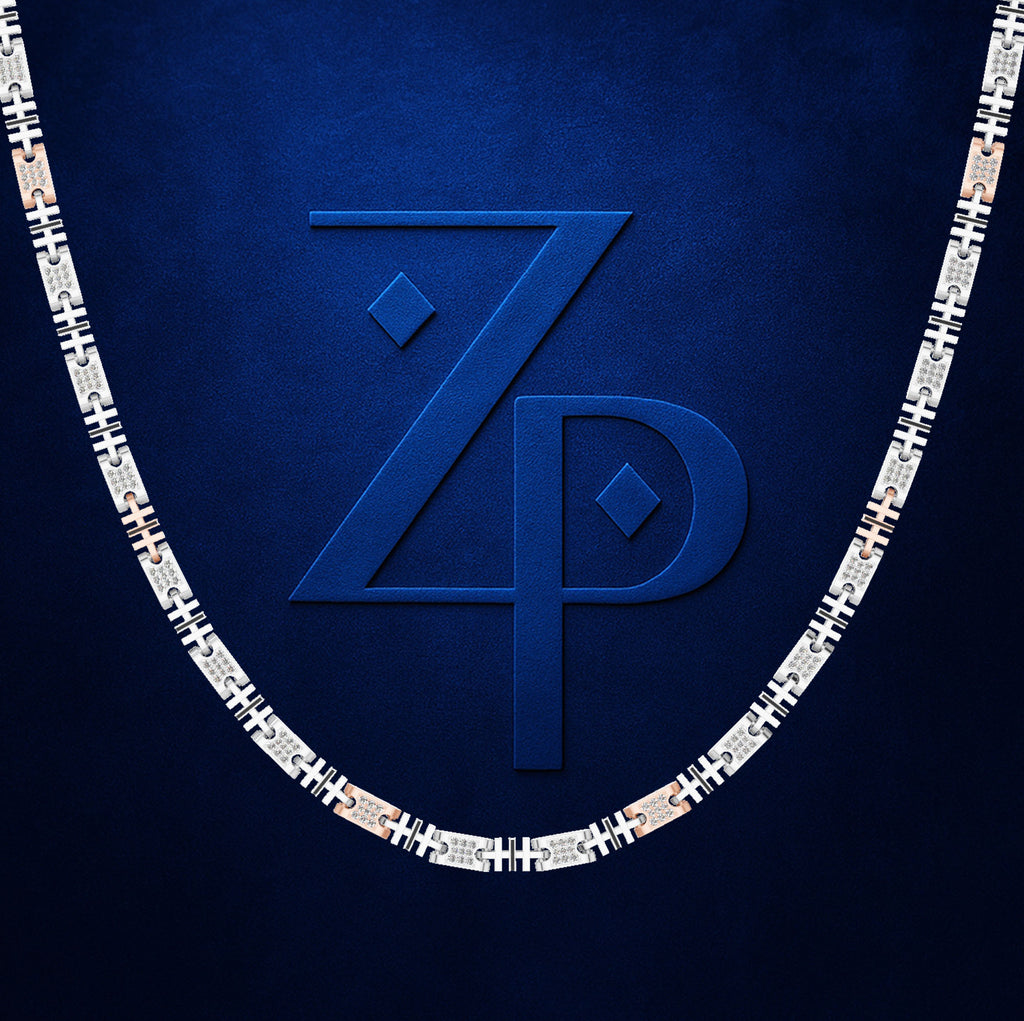 A close-up of a silver-toned chain necklace with repeating black and white geometric links, set against a textured dark blue background with a large embossed blue 'ZP' logo behind it.