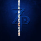 A close-up of a silver chain draped vertically over a dark blue textured background, with a large stylized blue 'ZP' monogram partially covered by the chain. A small section near the bottom shows a warm metallic copper/rose-gold tone.