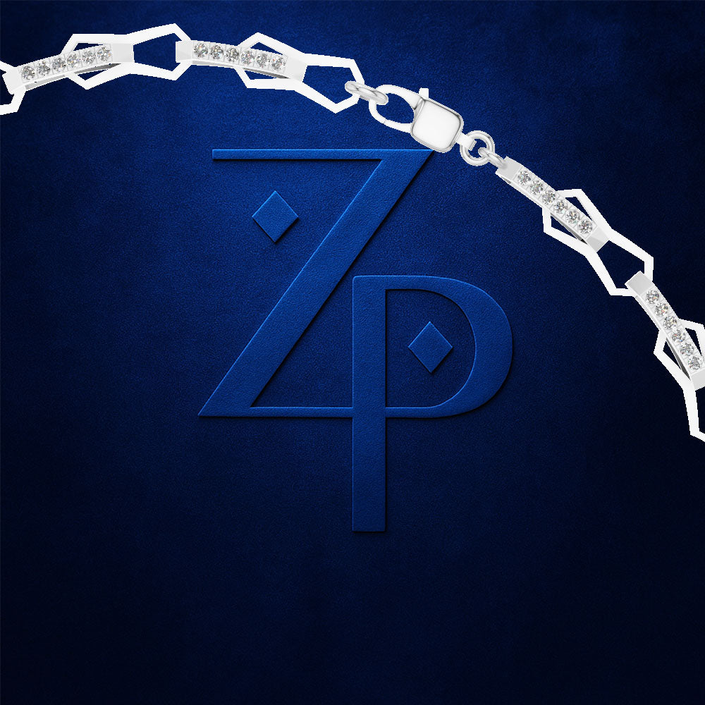 A silver-toned chain necklace with geometric links and clear stones, draped over a large embossed blue monogram logo on a textured dark blue background.