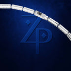 A close-up of a silver-toned cylindrical link chain, likely a bracelet or necklace, arcing across a dark textured blue background with a large embossed stylized 'ZP' logo behind it.