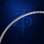 A close-up of a silver-toned metal chain with a few rose-gold links, set against a dark textured blue background with a large embossed stylized 'ZP' logo.