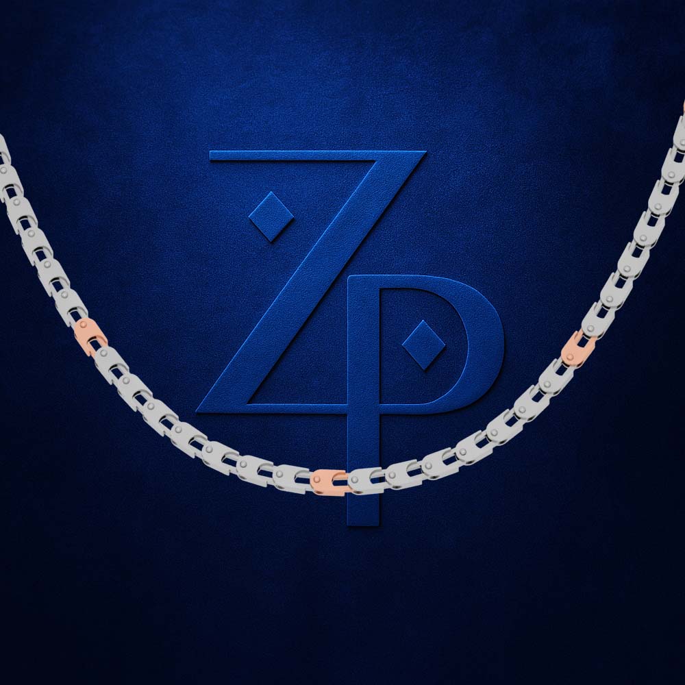A close-up of a silver-toned chain necklace with rose gold accent links, arranged in a U-shape against a textured dark blue background. A large embossed 'ZP' monogram is centered behind the chain.