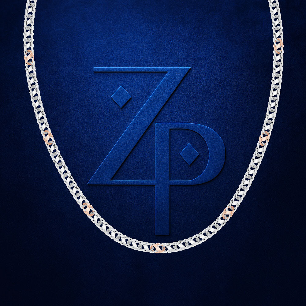 A silver-toned chain necklace with small rose gold accent links, arranged in an oval shape against a textured dark blue background. A large embossed 'ZP' monogram is visible in the center.