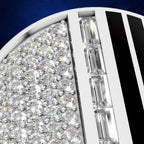 Close-up of a white jewelry setting filled with clear round and baguette-cut gemstones, set against a deep blue background.