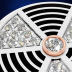 Close-up of a jewelry setting featuring multiple clear round gemstones arranged in triangular sections, with a rose-gold circular bezel holding a central clear stone. The background is split between black and deep blue.