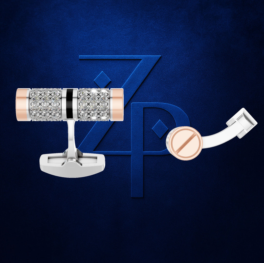 A pair of men's cufflinks displayed against a dark blue textured background with a large blue 'ZP' logo. The cufflinks feature a silver-toned metal base, a central cylindrical section covered in clear pavé-set stones, a thin black accent band, and rose gold-toned end caps.