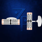 A pair of men's cufflinks displayed on a textured dark blue background. The cufflinks feature a cylindrical design with rows of clear pavé-set stones, a polished rose gold end, a polished silver-toned center band with a black stripe, and a flat white post backing.