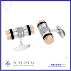 A pair of cylindrical cufflinks by Platinzem, featuring a silver-toned body with black enamel stripes, a central diamond-encrusted band, and rose gold end caps, shown on a white background with the Platinzem brand logo at the bottom.