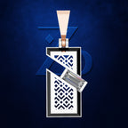 A rectangular silver-toned pendant with a white and navy geometric cutout pattern, hanging from a matching silver chain against a dark blue textured background.