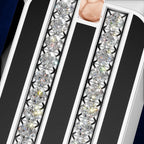 Close-up of a white and black striped phone case decorated with two vertical rows of clear round-cut gemstones, with a small inset showing a hand holding the case.