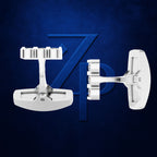 A pair of white men's cufflinks displayed against a textured dark blue background with a stylized blue 'ZP' logo behind them.
