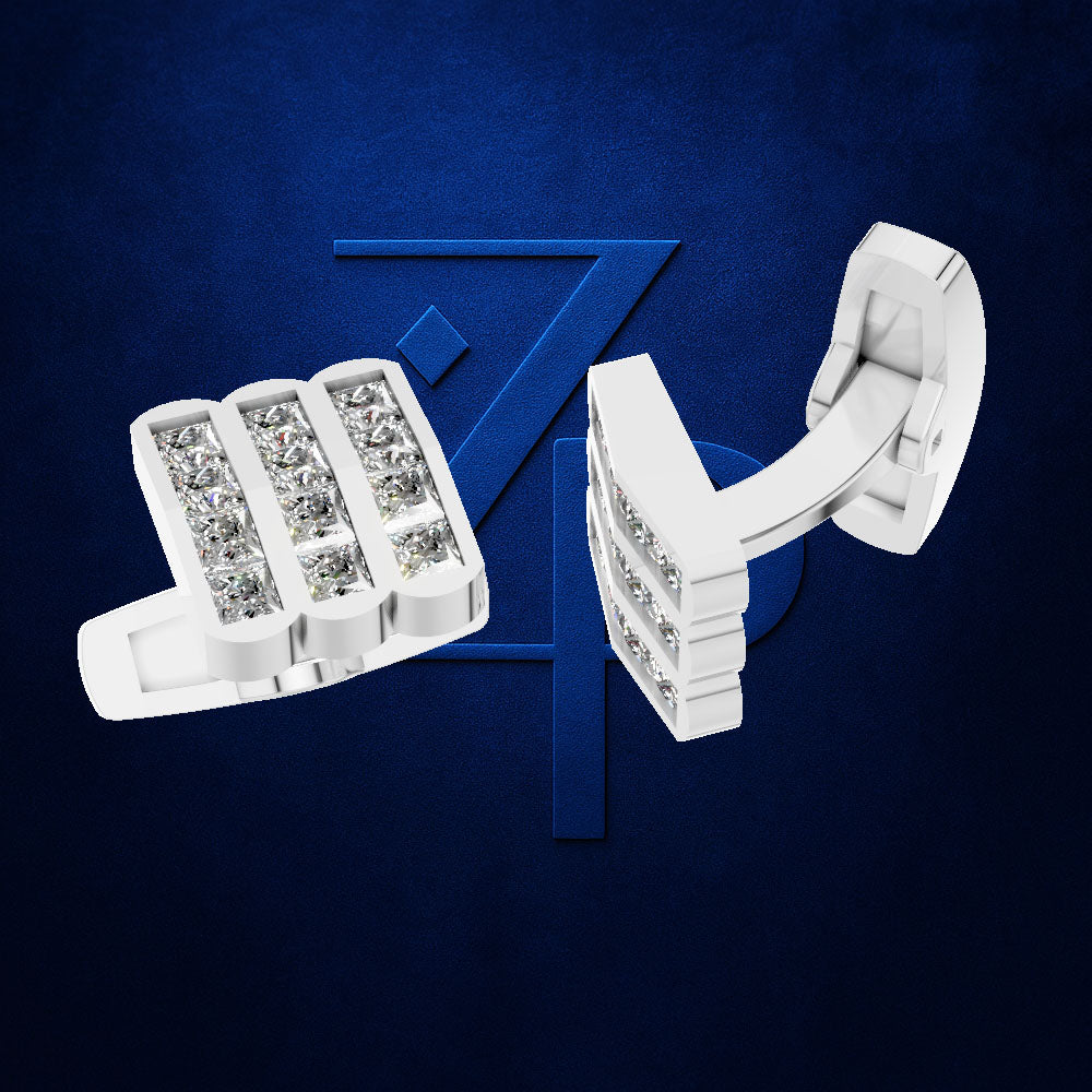 A pair of white cufflinks with rectangular clusters of clear gemstones, shown on a dark blue textured background with a large blue stylized Z logo behind them. The cufflinks are displayed from two angles: one showing the front face with the stones and the other showing the side profile and back clasp.