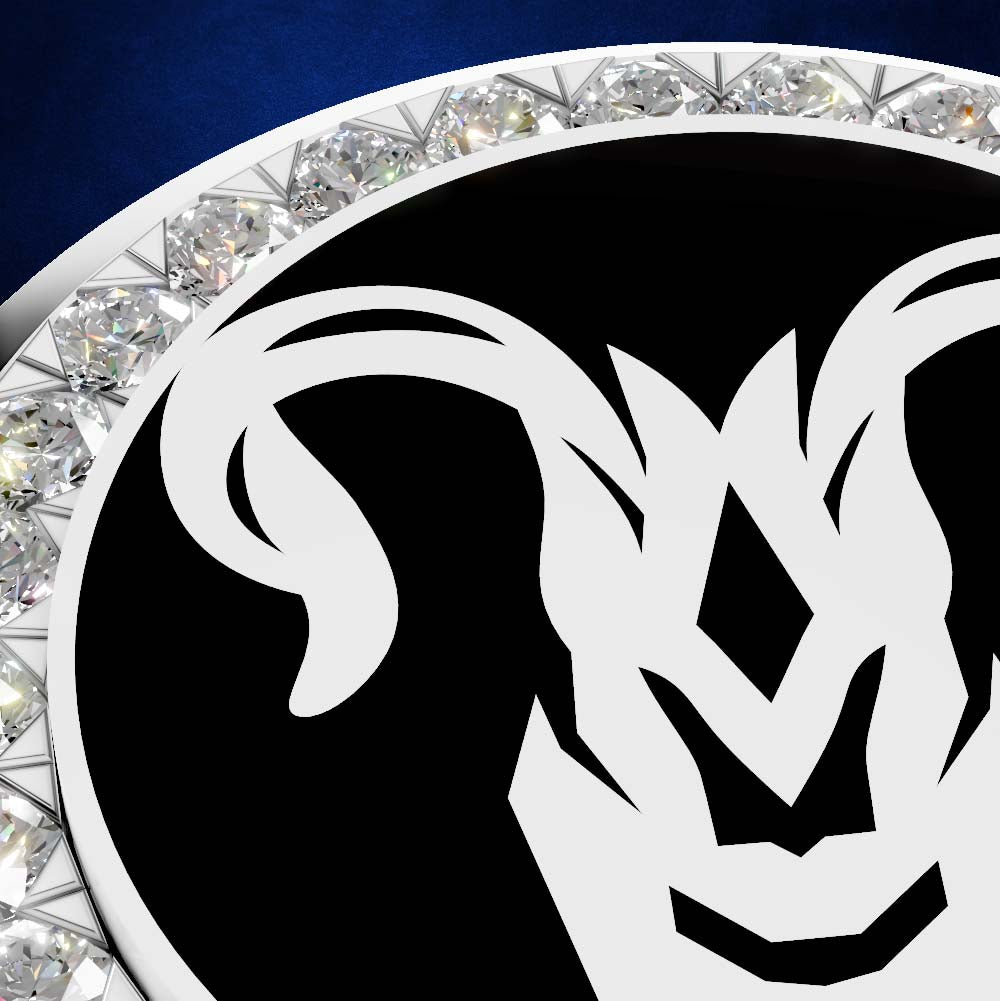 A close-up of a circular black and white ram head emblem or medallion, surrounded by a border of clear faceted gemstones on a dark blue background.