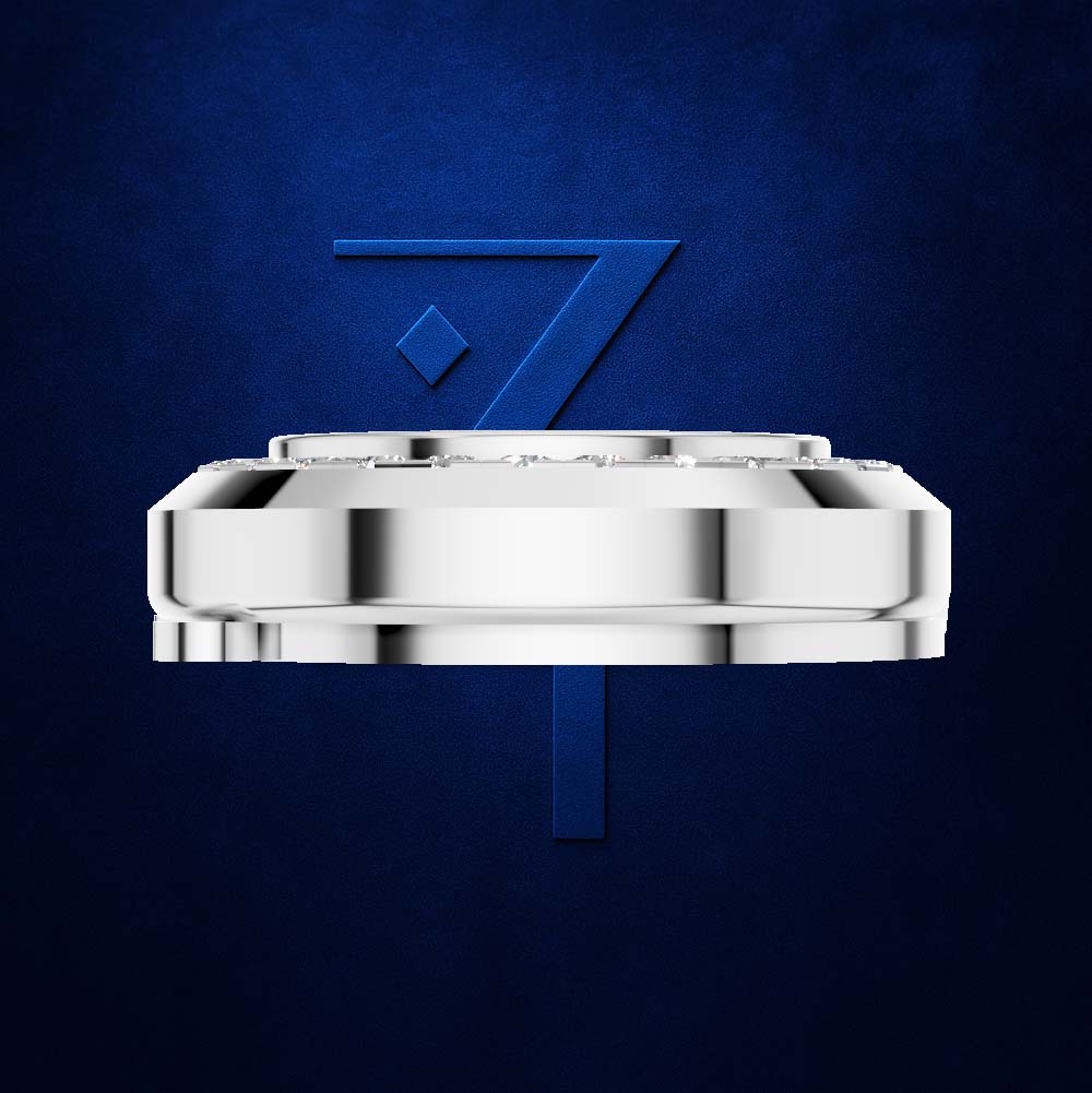 A polished silver-toned circular product, likely a watch crown or decorative hardware piece, centered against a textured dark blue background with a large blue stylized '7' behind it.