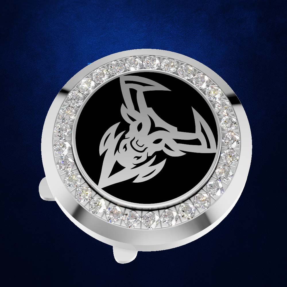 A round silver-toned car horn button cover featuring a black center with a stylized white ram's head emblem, surrounded by a border of clear rhinestones, set against a dark blue textured background.