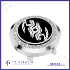 A round silver-toned golf ball marker cap featuring a black center with a white stylized bird emblem, surrounded by a halo of clear crystals. The brand name 'PLATIZEM' is visible at the bottom of the image.