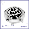 A round golf flag hole marker with a polished silver-tone metal body, a black center featuring a white stylized bird emblem, a halo of clear rhinestones, and a small flagstick extending downward. The brand name PLATIZEM is visible at the bottom of the image.