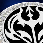 Close-up of a circular jewelry piece featuring a bold black and white ornamental pattern, surrounded by a border of clear faceted gemstones on a white metal setting, against a deep blue background.