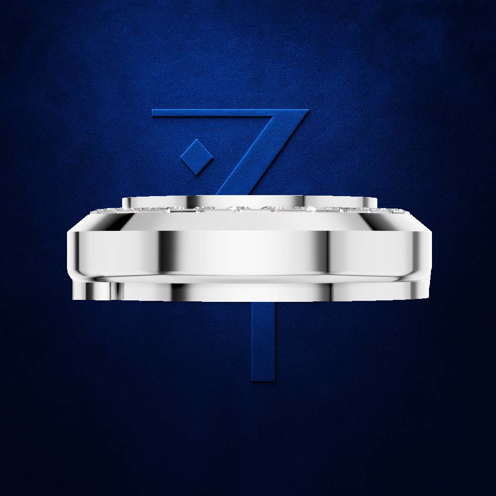 A polished silver-toned metal watch crown or watch component centered on a textured dark blue background, with a stylized blue number 7 behind it.