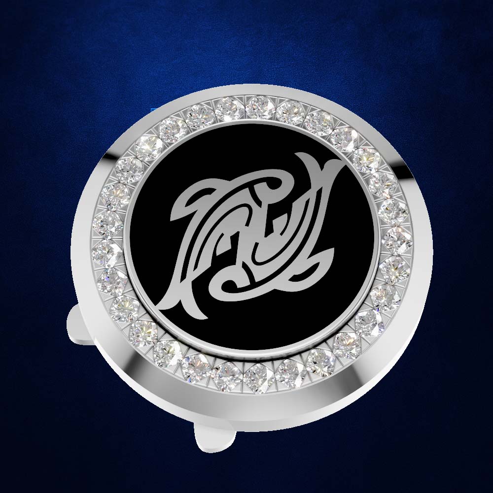 A round silver-toned golf ball marker with a black center featuring a white stylized fish logo, surrounded by a halo of clear rhinestones, set against a dark blue textured background.