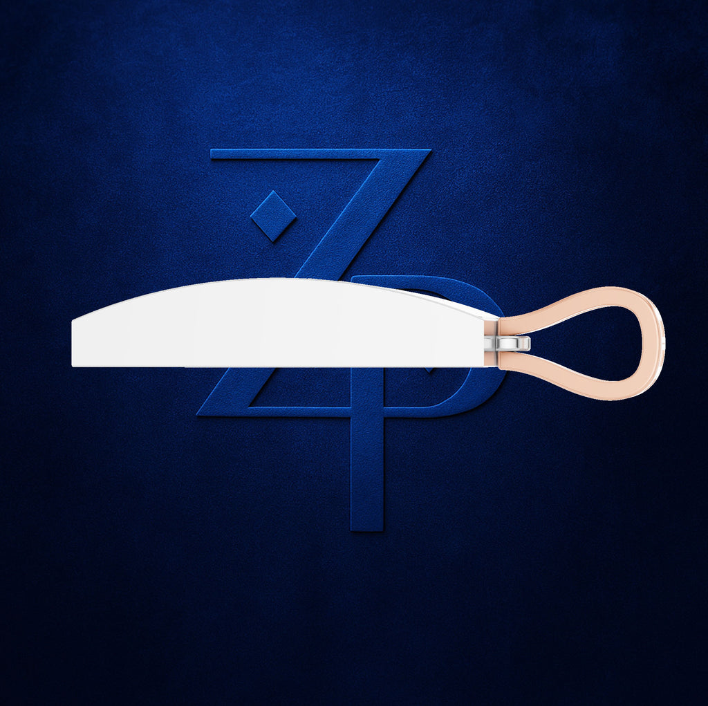 A modern kitchen knife with a wide, curved white blade and a light peach-colored loop handle, presented horizontally against a dark textured blue background with a stylized blue 'ZP' monogram.