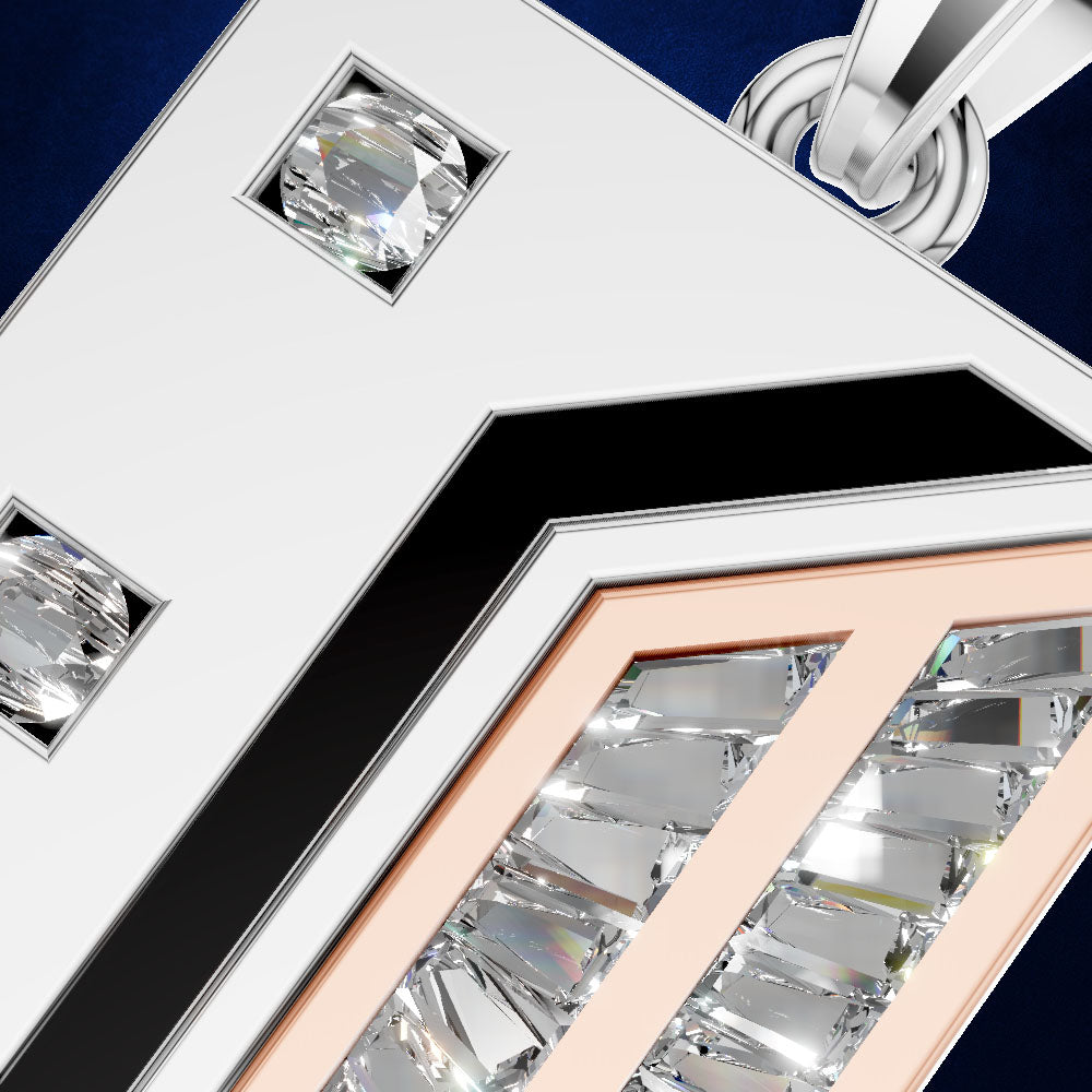 Close-up of a geometric silver-toned pendant or brooch with clear faceted gemstones, a black chevron accent, and a rose-gold inner frame, shown against a dark blue background.