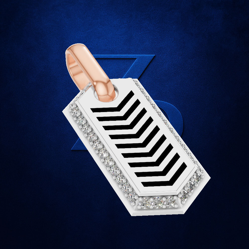 A rectangular silver-toned pendant with a rose gold loop, decorated with a border of clear crystals and bold black chevron stripes, set against a textured dark blue background.