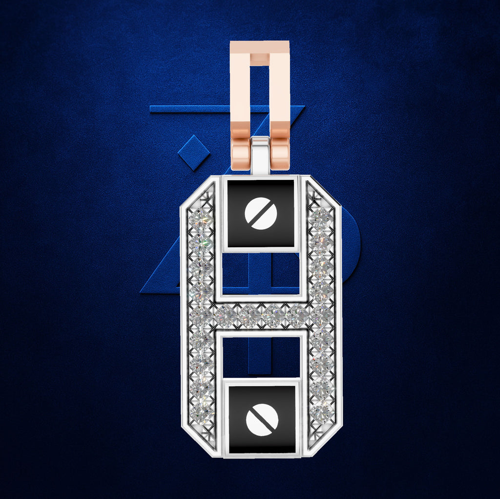 A luxury jewelry pendant featuring a rose gold U-shaped bail, a silver-toned frame encrusted with clear crystals, and two black square inlays with white circular details, set against a textured dark blue background.