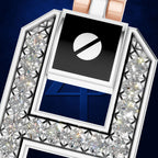 A close-up of a luxury jewelry pendant or brooch featuring a silver-toned geometric frame set with clear faceted gemstones. The center contains a black square with a white circle-and-slash symbol above a deep blue insert showing the number 4.