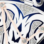 Close-up detail of a watch dial with a white and navy blue graphic design, silver-tone bezel and hands, and clear crystal accents.