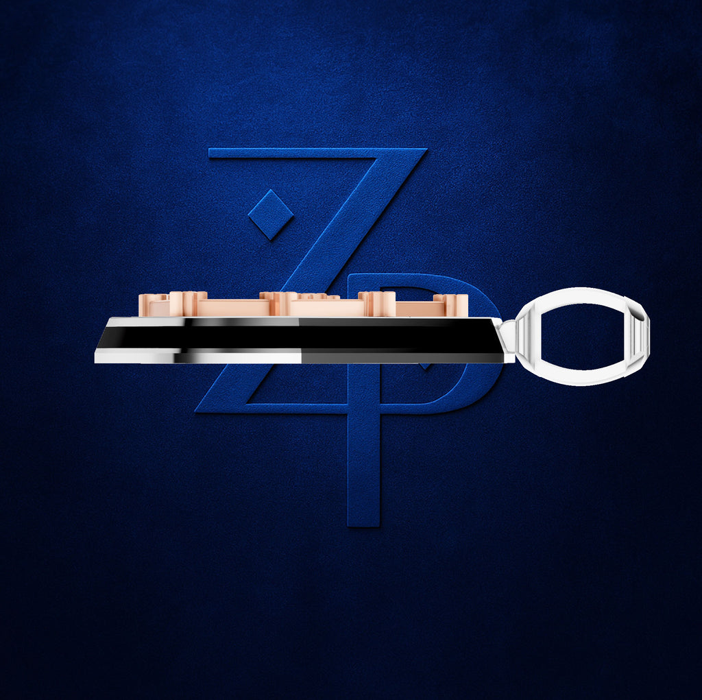 A metallic key-shaped accessory with a polished silver handle and a black central bar, featuring a row of small rose-gold rectangular elements along the top, set against a textured dark blue background with a large stylized blue 'ZP' logo.