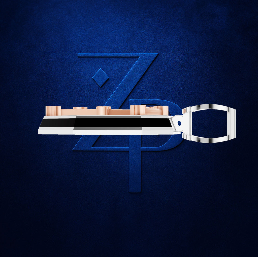A modern key-shaped accessory with a metallic silver handle and a top bar featuring rose gold and black segments, presented against a textured dark blue background with a stylized blue 'ZPD' logo.