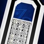 Close-up of a luxury jewelry piece featuring a rectangular array of clear pavé diamonds in a silver-toned setting, set against a deep blue textured background with bold white and black geometric borders.