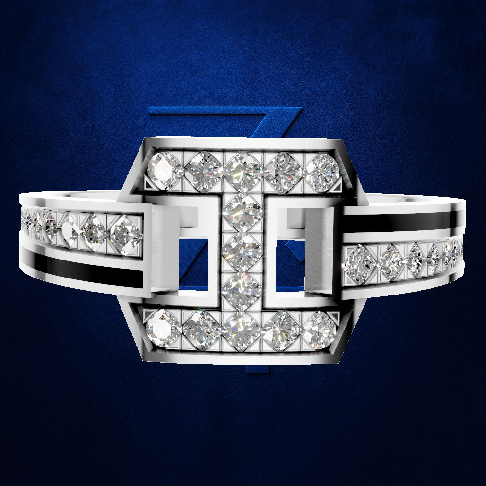 A geometric silver ring with pavé diamonds and blue inlay accents, presented on a textured dark blue background with a subtle brand logo behind it.
