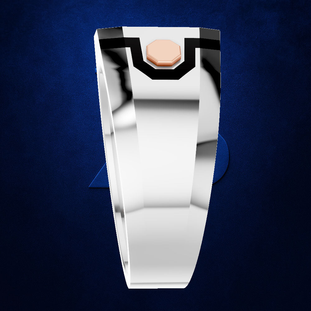 A polished silver-toned ring with a small rose gold hexagonal accent at the top, shown against a textured dark blue background.
