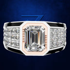 An emerald-cut diamond ring with a silver-toned band, accented by black inlays and rows of small diamonds on the shoulders, set against a dark blue textured background.